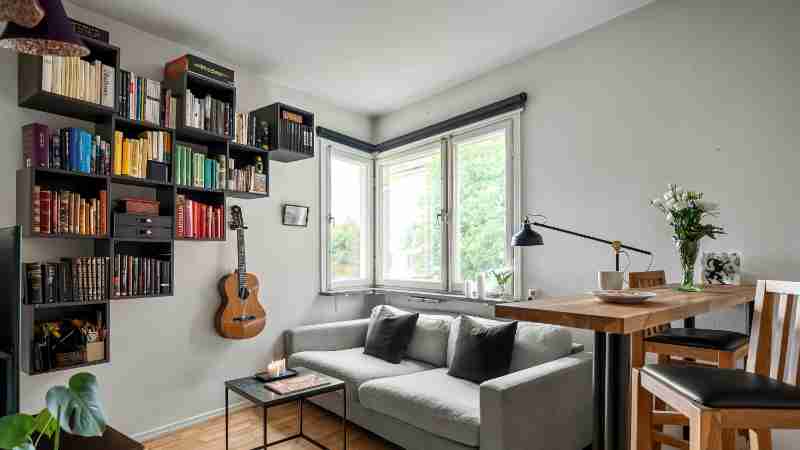 Inviting living room interior with bookshelves, guitar, and grey couch under natural light., tags: 2026 - pexel